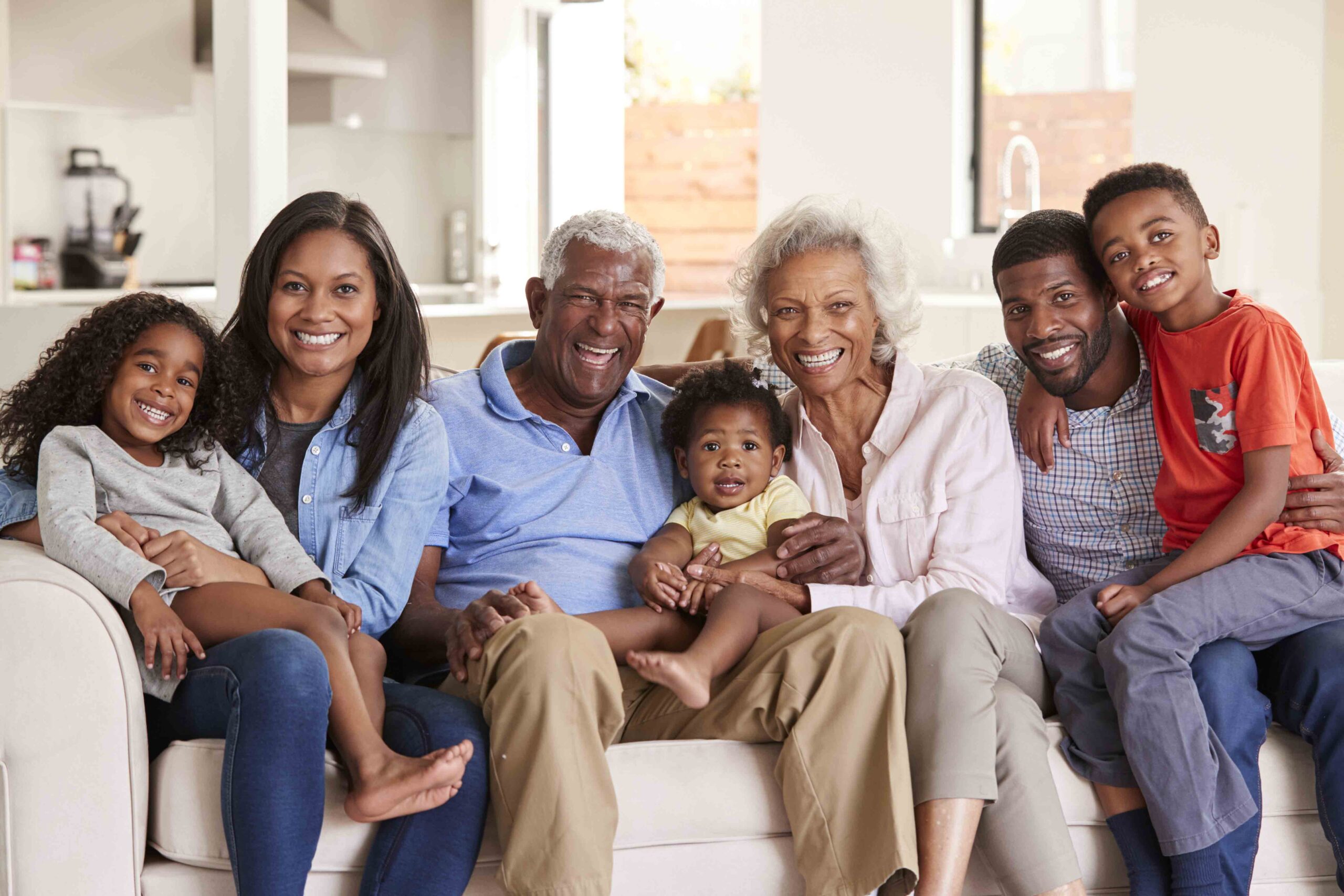 Happy multi-generational family sitting together on a couch at home