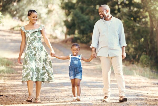 Happy family walking together outdoors, highlighting the importance of shared parenting and support for the child.