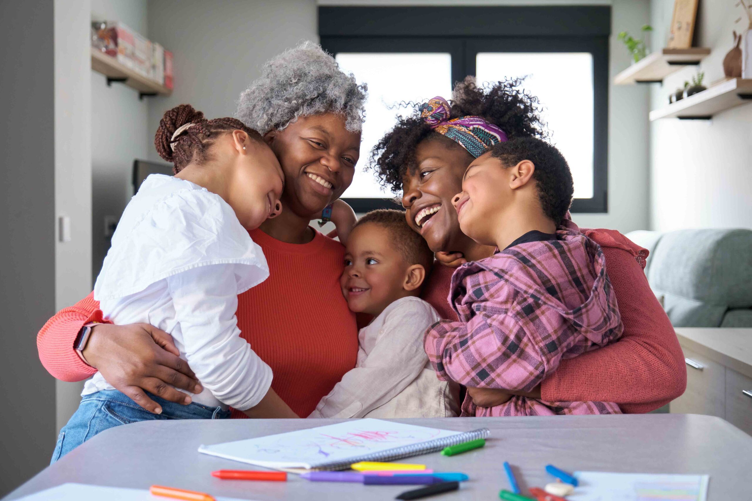 Extended family hugging and laughing together, showing the benefits of family support in relocation and custody decisions.