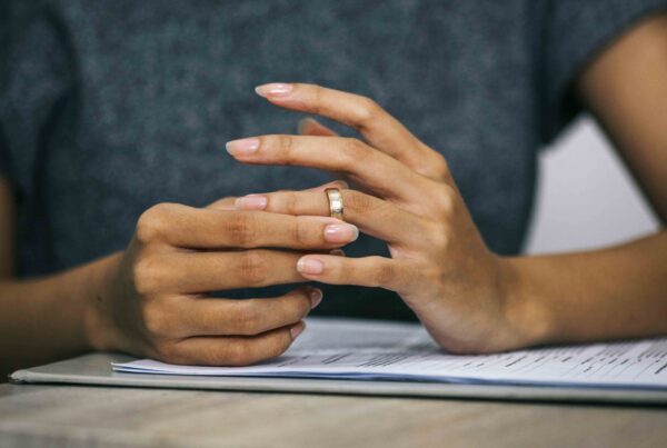 Person removing a wedding ring, representing the process and duration of an uncontested divorce in Texas.