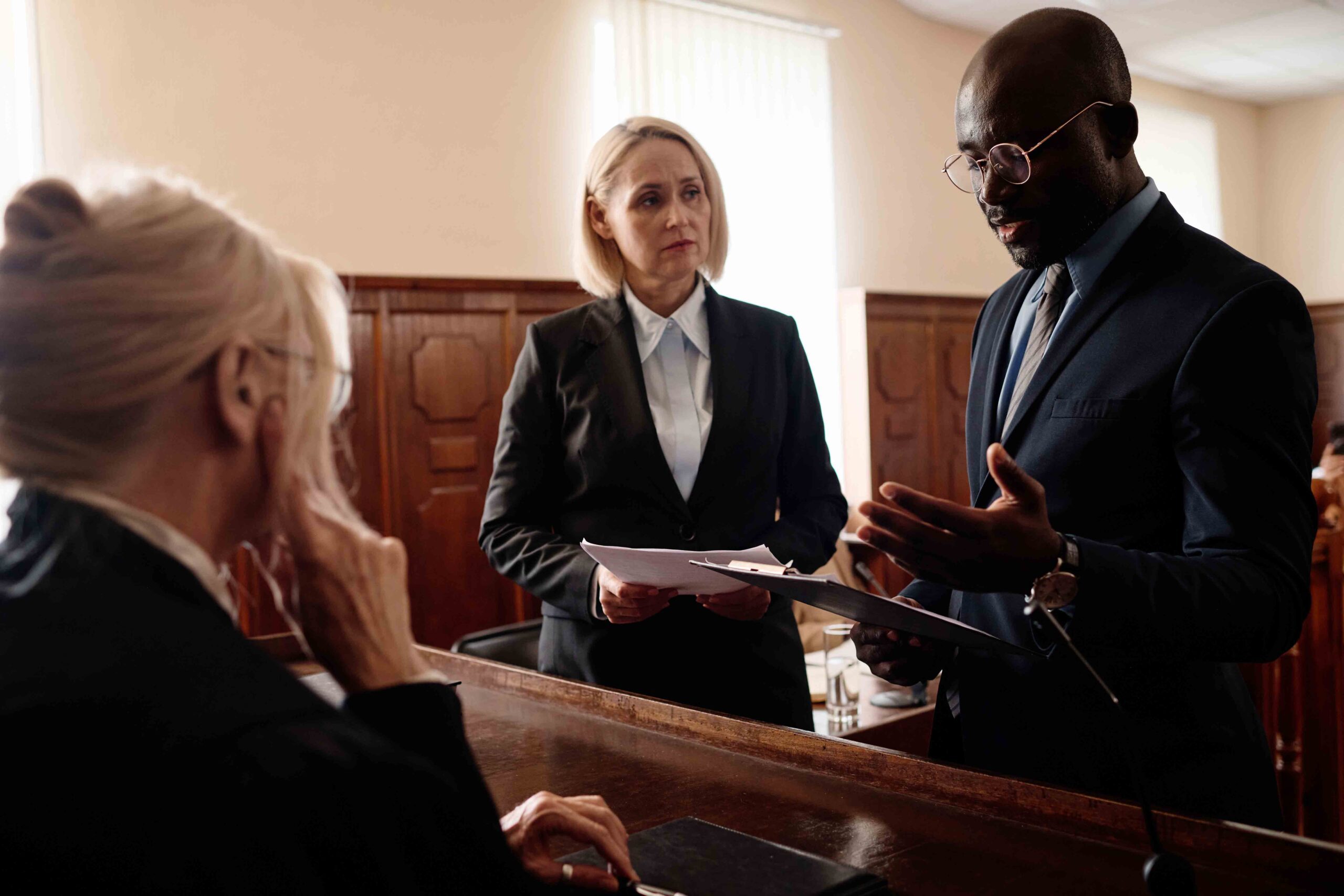 Judge reviewing divorce agreement with two attorneys in court, illustrating the approval process of a divorce agreement.