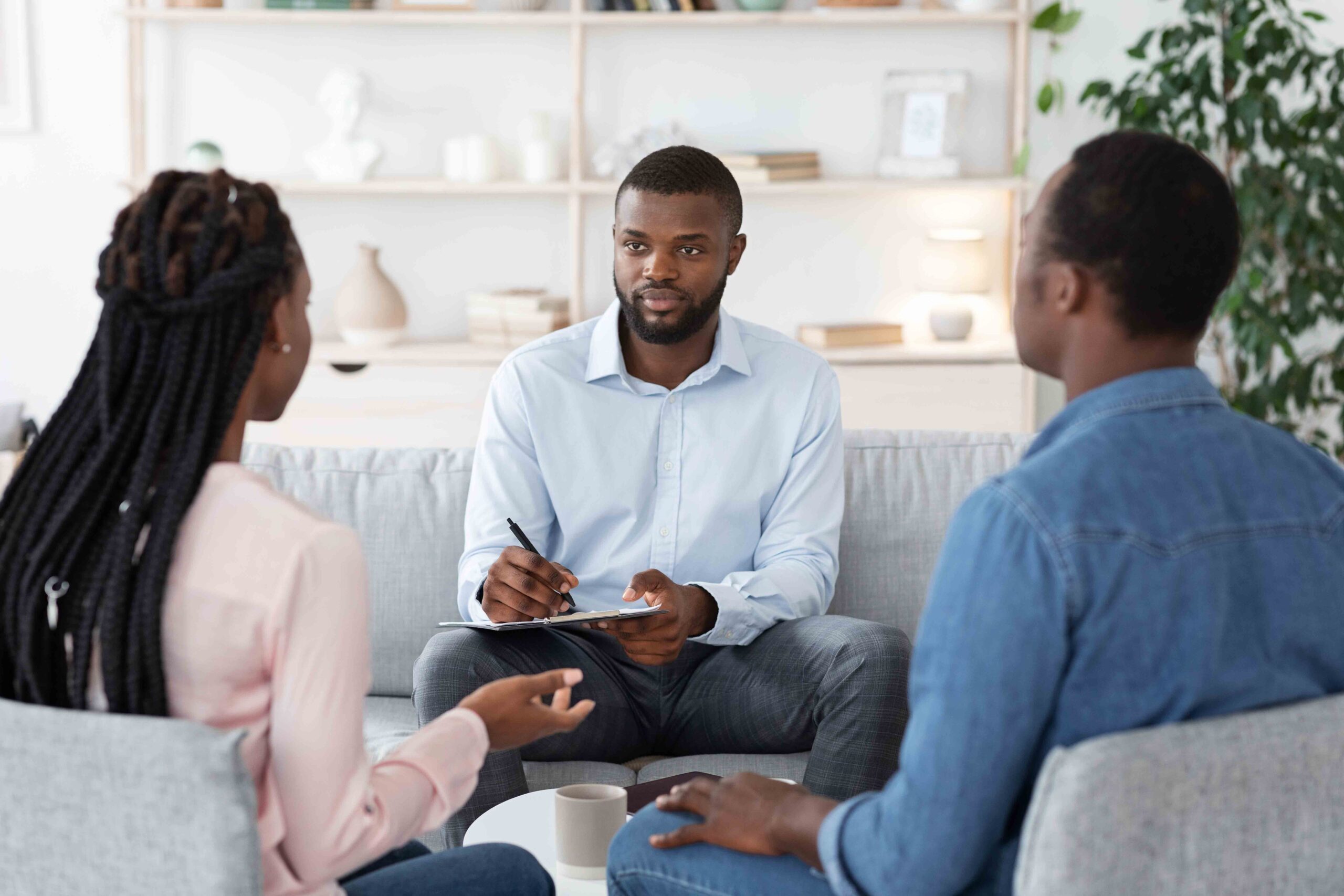 Marriage counselor listening to a couple during a session, highlighting mediation and negotiation in parental rights cases.