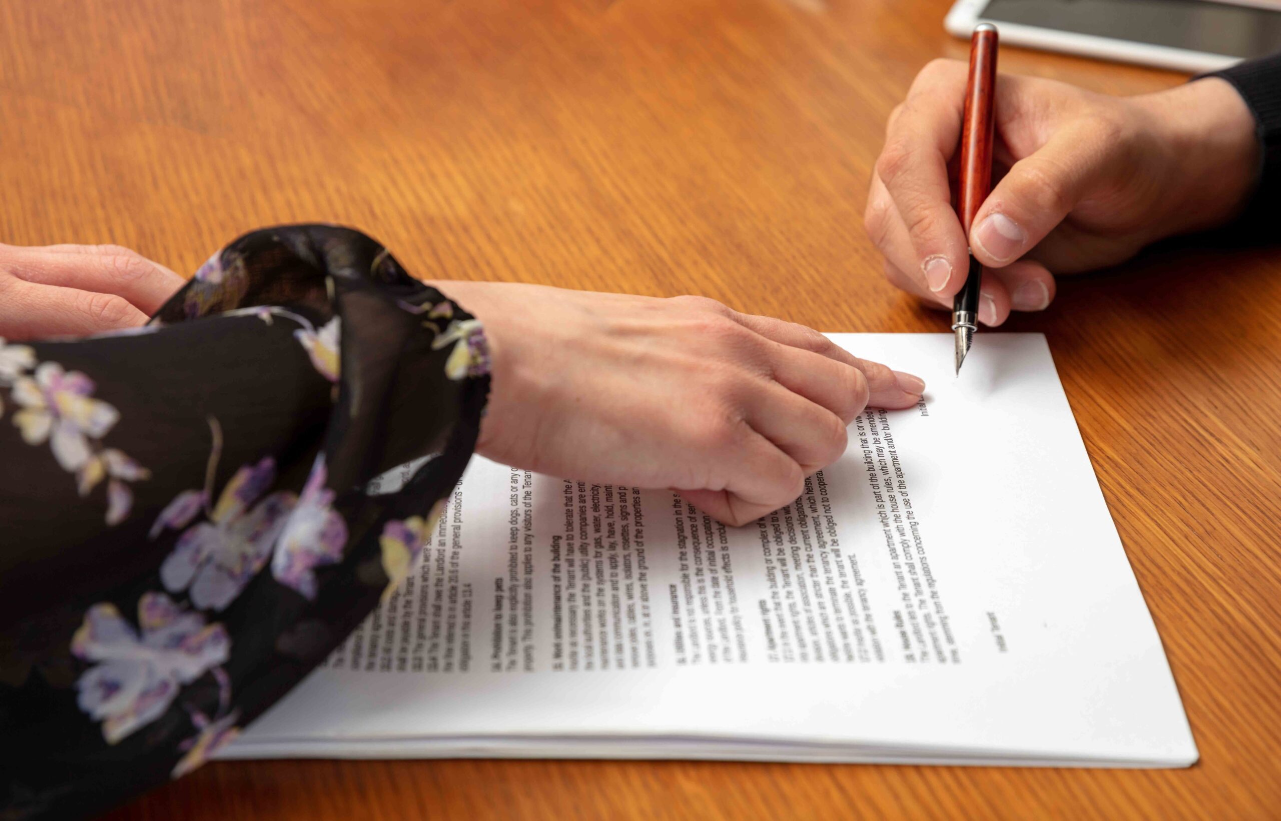 Person signing a document under duress, illustrating conditions of lack of voluntary consent in legal agreements