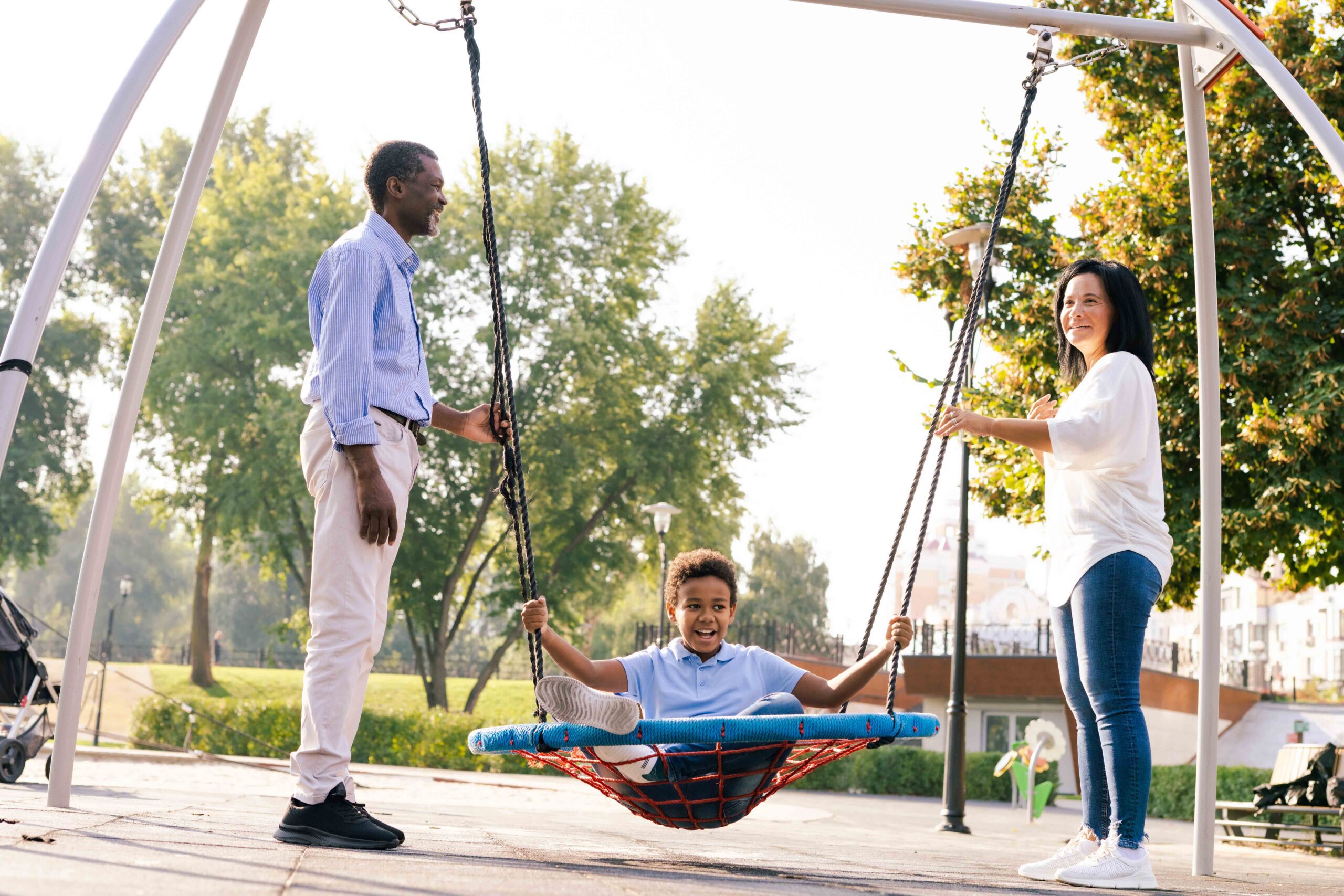 Parents with child on swing, exemplifying co-parenting relationships by waiving child support in Texas