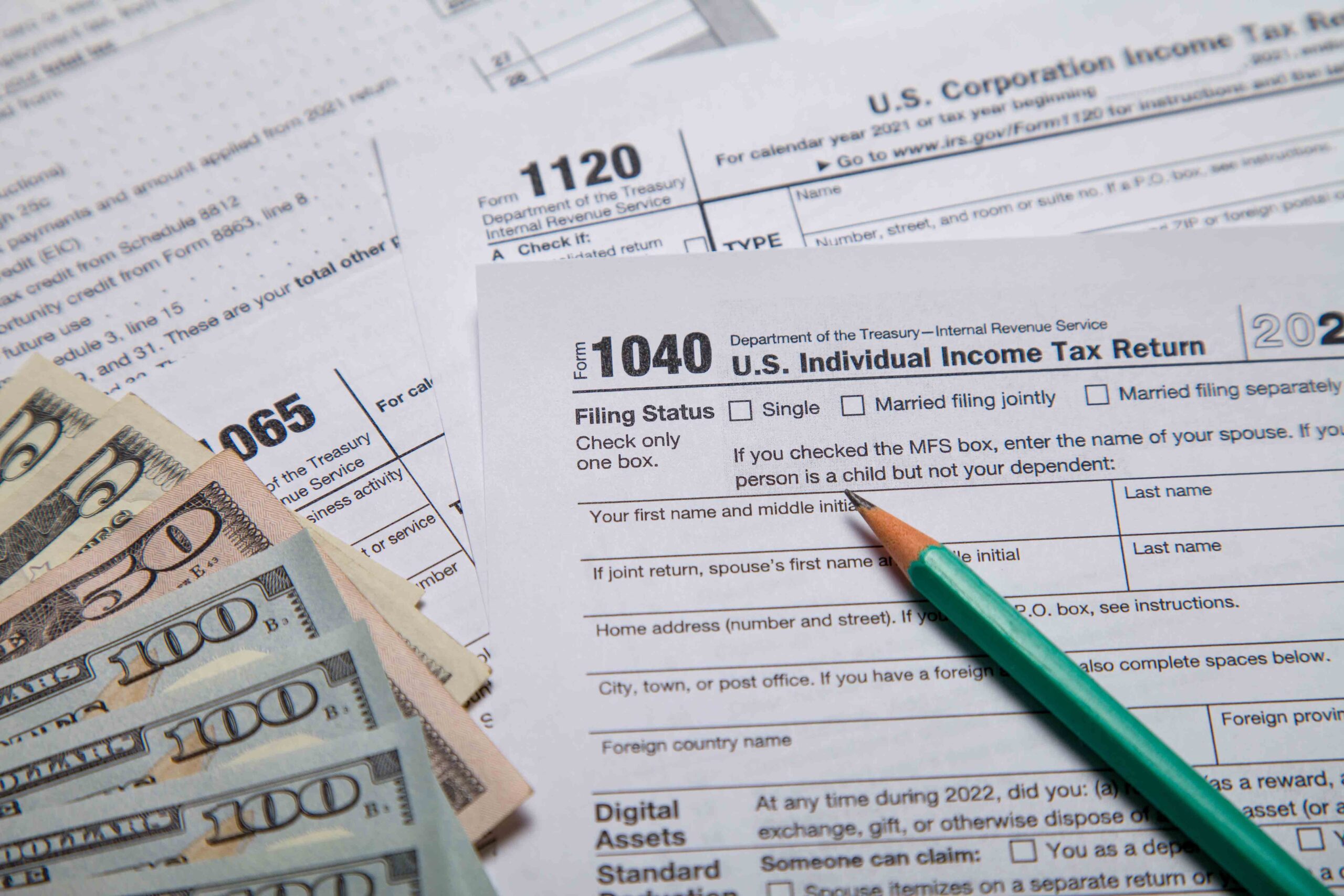 Close-up of a 1040 tax form with a pen and cash, representing the interception of tax refunds and lottery winnings for unpaid child support