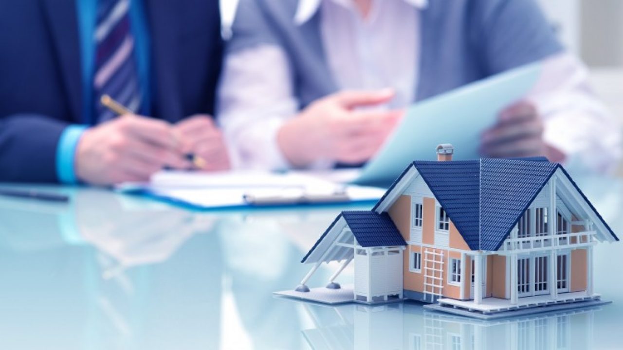 Model of a house on a table with paperwork, symbolizing the complexity of dividing assets in divorce, such as real estate and business ownership