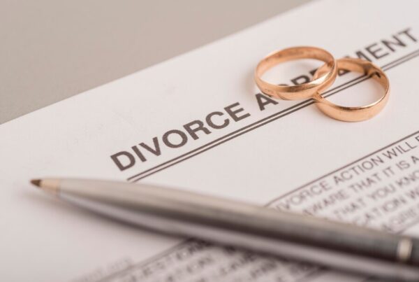 Close-up of two wedding rings on a divorce agreement document, symbolizing the end of a marriage