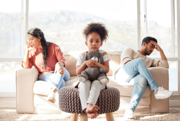 Parents in a tense discussion with a mediator during child custody mediation, focusing on resolving disputes in the best interest of the child