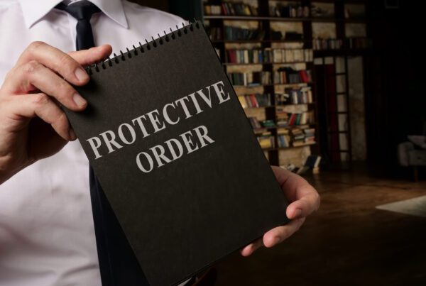 A lawyer holding a notepad with "Protective Order" lettering on the cover