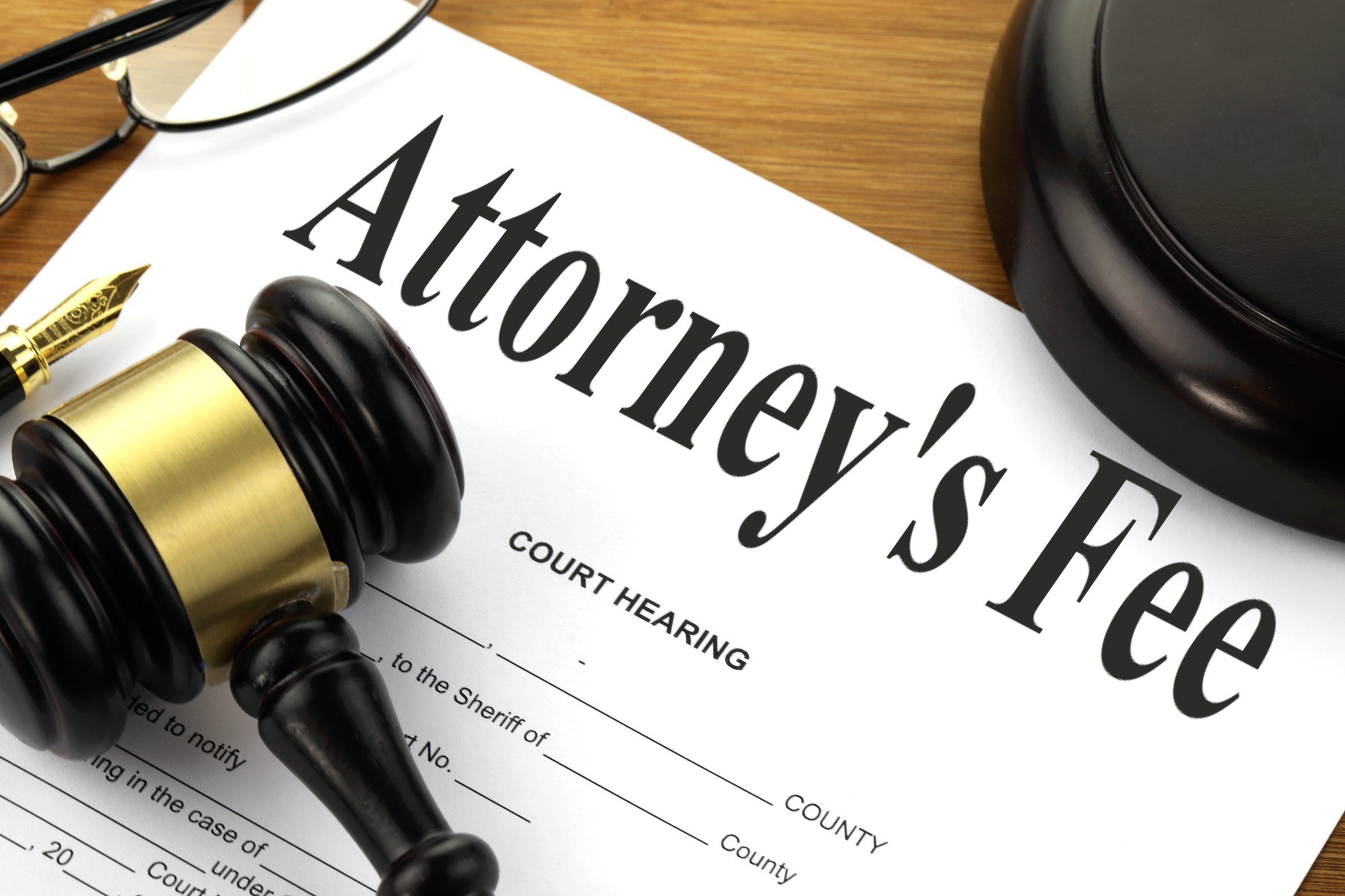 A gavel and a document labeled "Attorney's Fee" on a desk, symbolizing legal costs in court hearings, relevant to attorney fees in Texas child custody cases