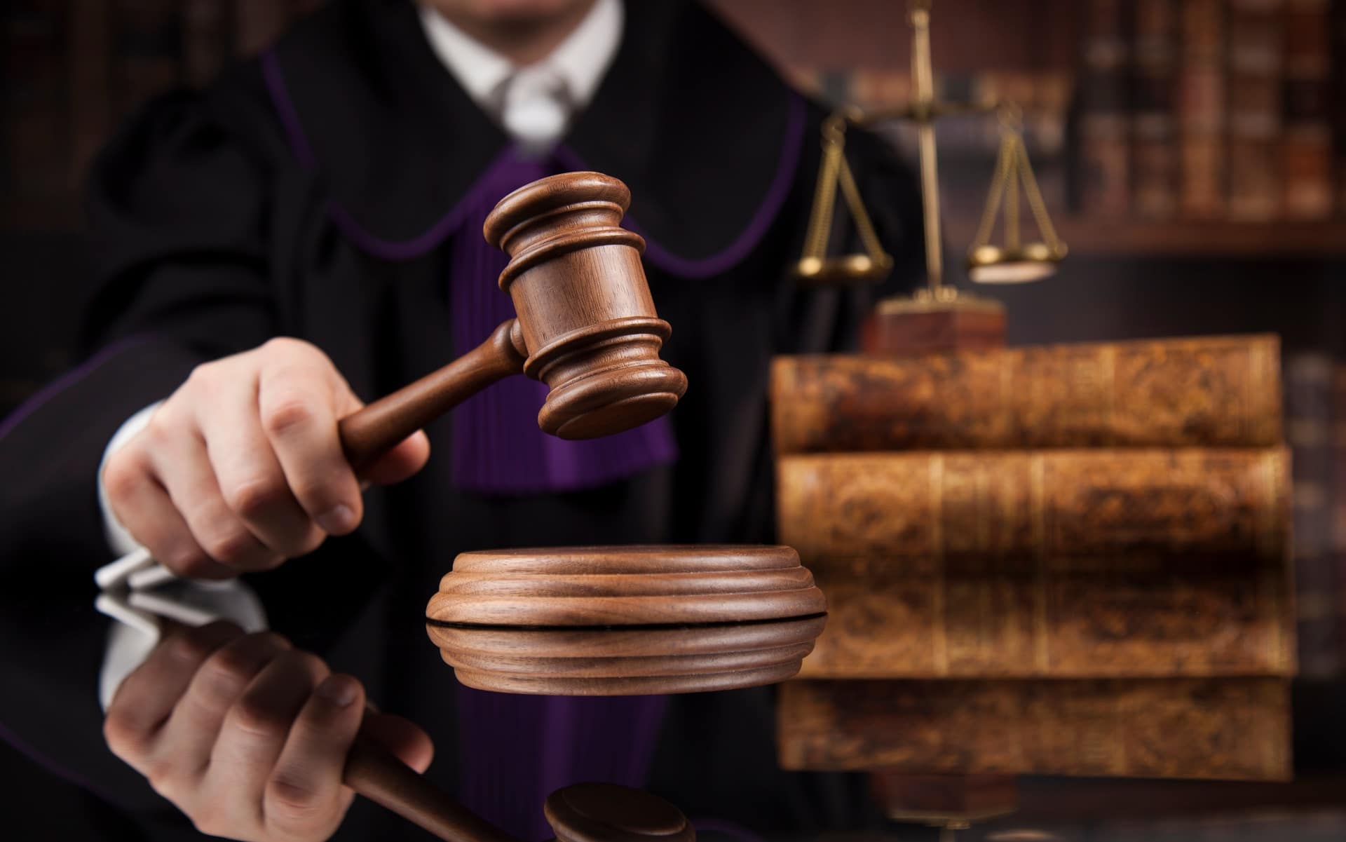 A judge raises a gavel above a wooden table, symbolizing authority in a divorce proceeding without legal representation