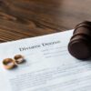 Divorce papers and a gavel symbolize the enforcement of a divorce decree in a legal context