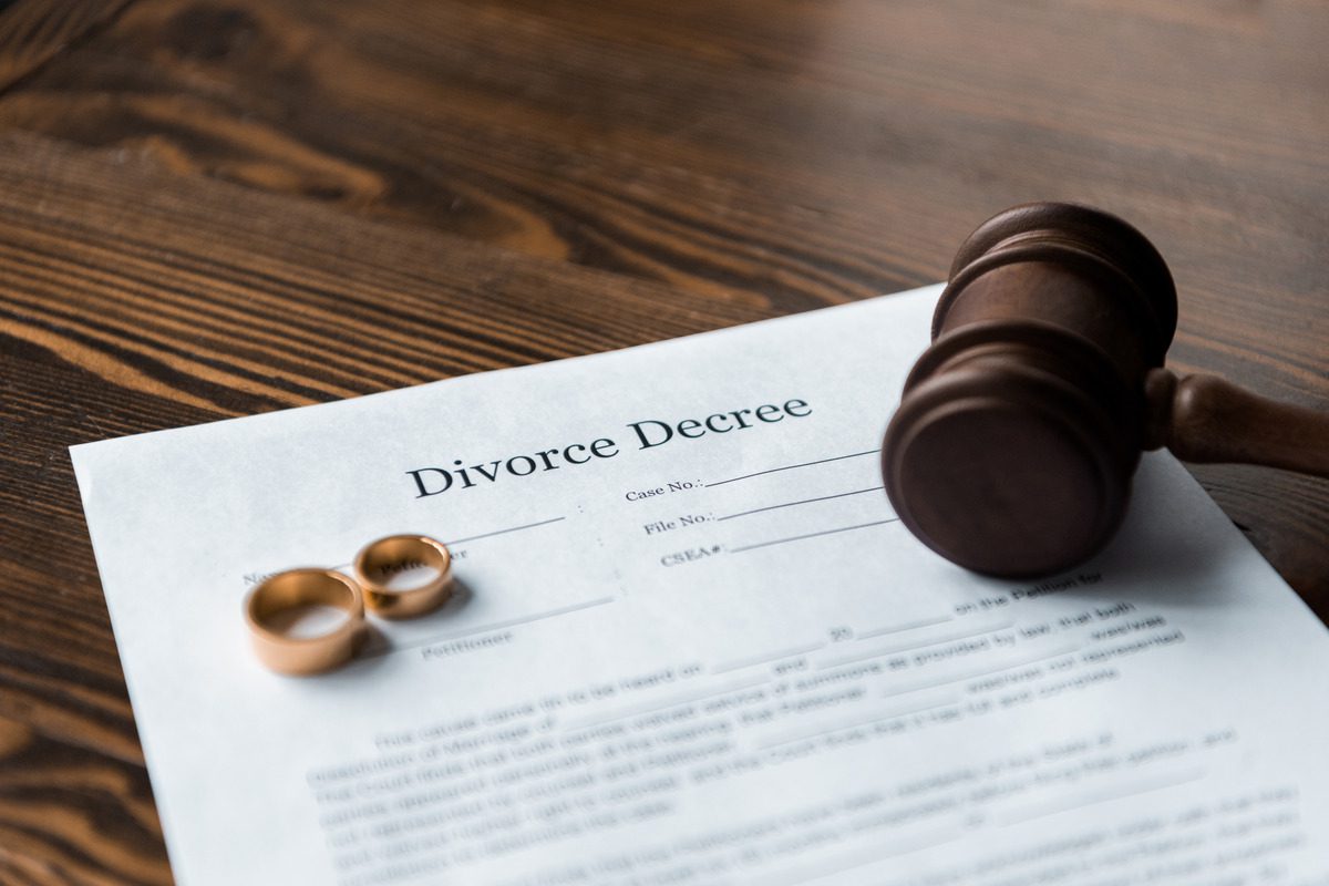 Divorce papers and a gavel symbolize the enforcement of a divorce decree in a legal context