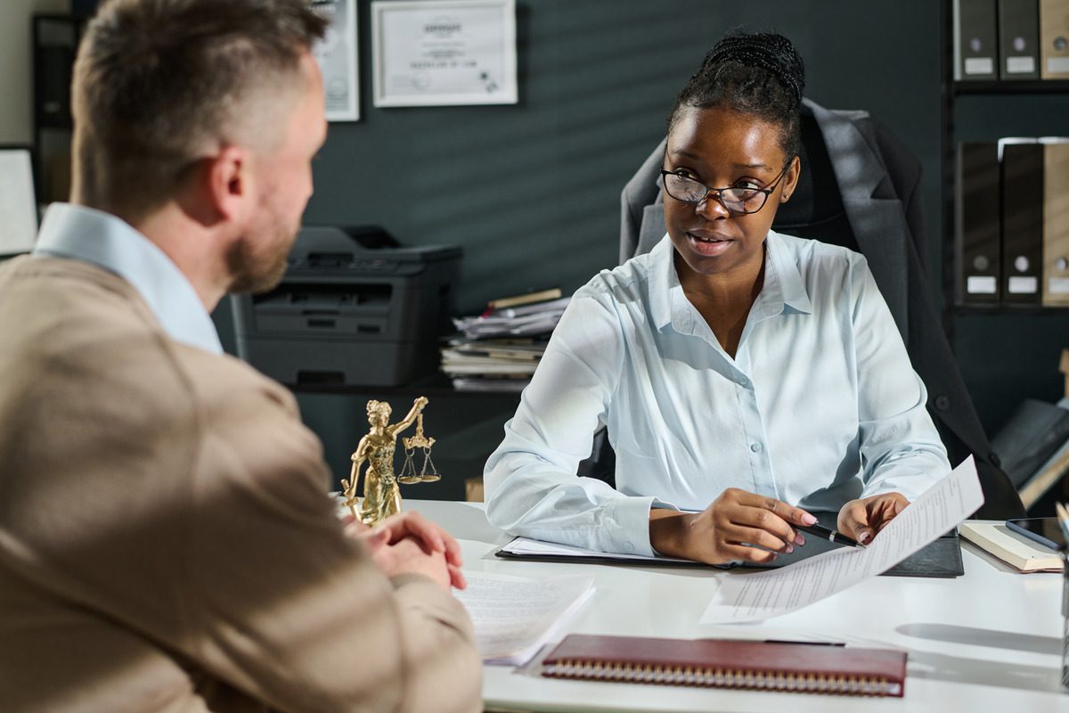 A family lawyer consults with a client in an office, discussing child support legal options and consequences of non-payment