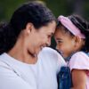 A joyful woman and her daughter embrace, sharing a warm moment filled with laughter and love