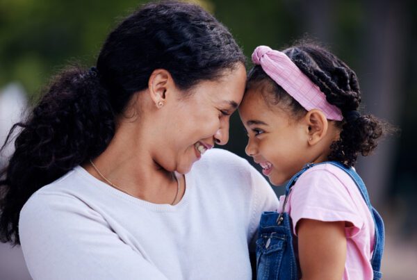 A joyful woman and her daughter embrace, sharing a warm moment filled with laughter and love