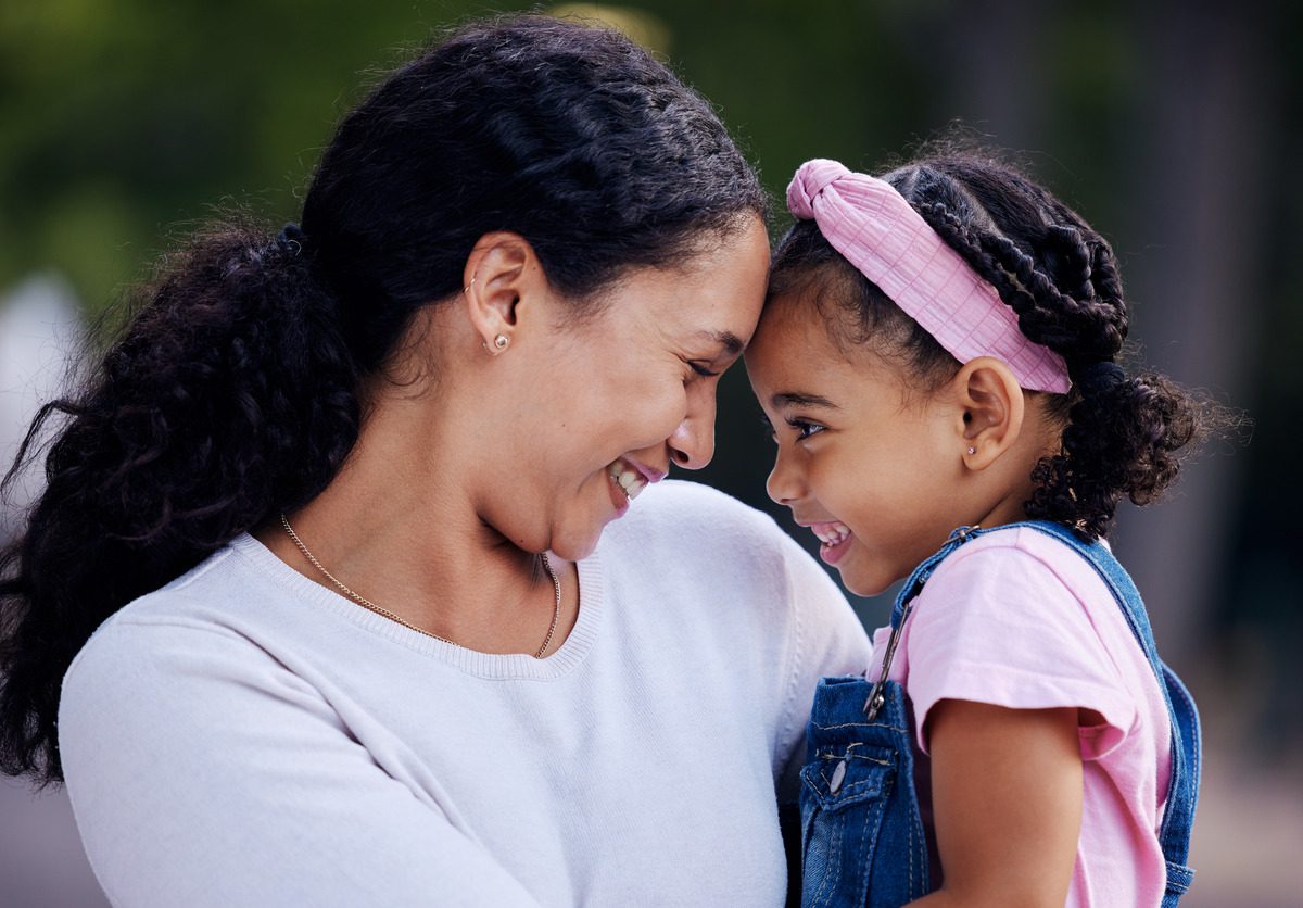 A joyful woman and her daughter embrace, sharing a warm moment filled with laughter and love