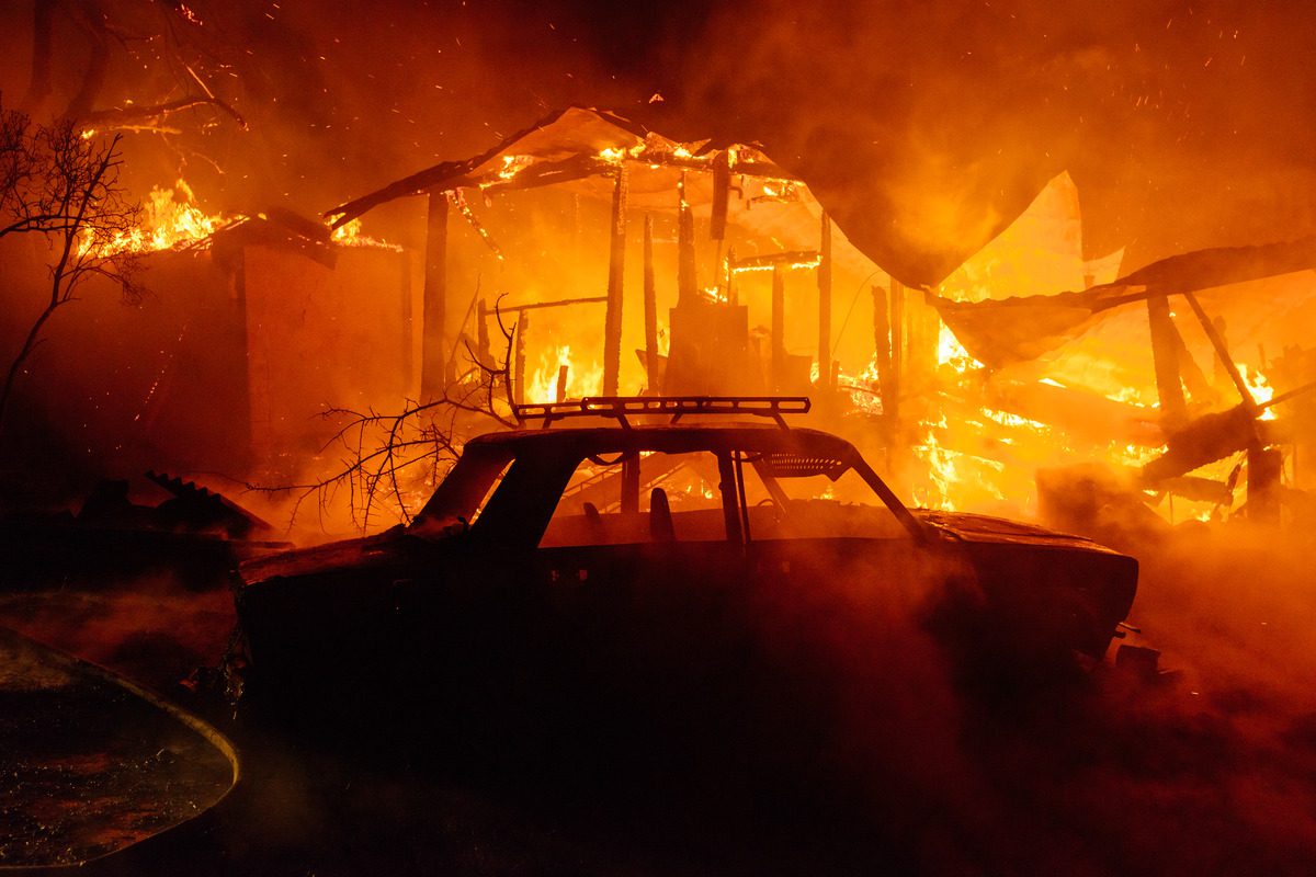 A car engulfed in flames, illustrating a scene of potential arson amidst a raging fire