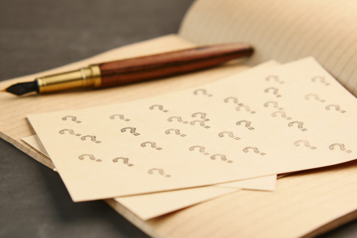 Question marks on paper with a pen, symbolizing inquiries about the proceedings at a TRO hearing