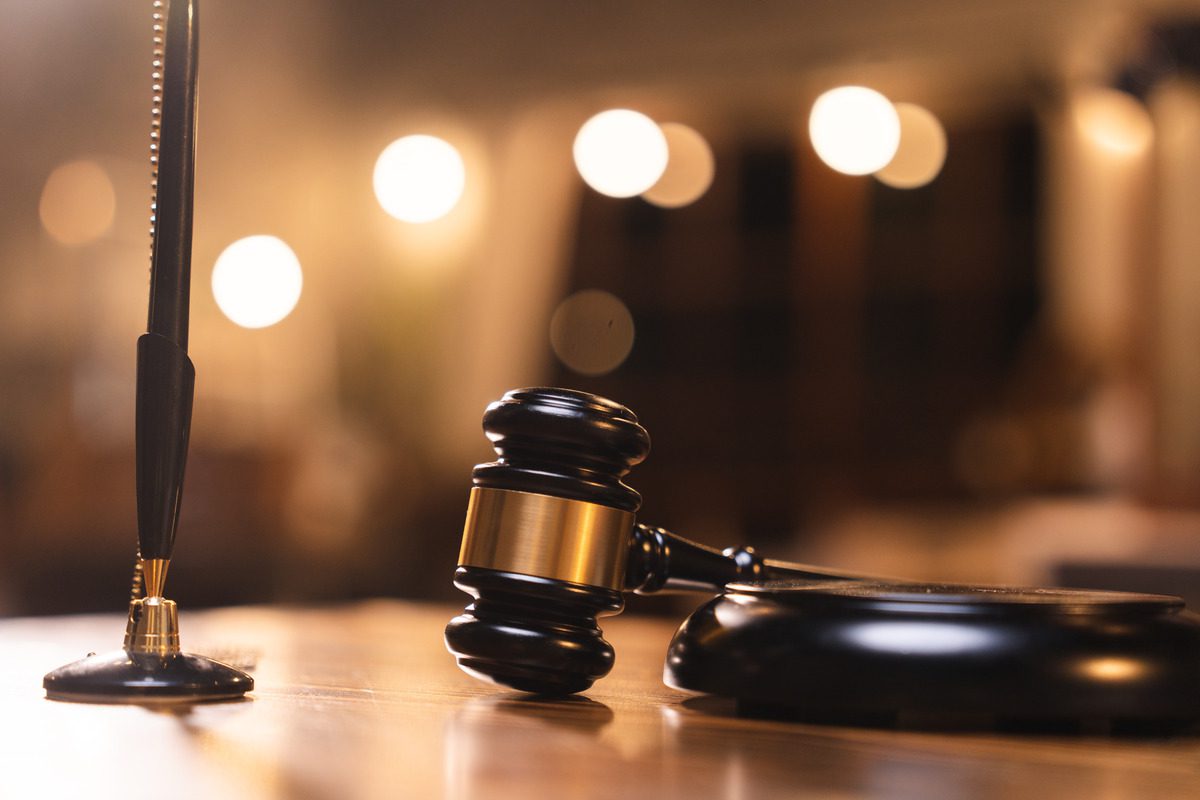 A judge's gavel and pen resting on a wooden table, symbolizing legal proceedings related to child support issues