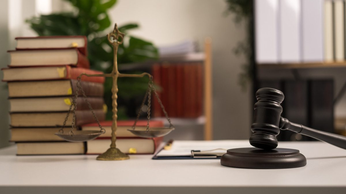 Judge's gavel resting on a stack of legal books on a desk, symbolizing justice and legal proceedings