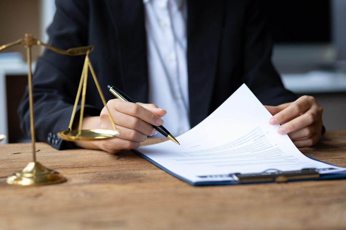 A lawyer drafting a contract with a client, emphasizing the importance of clear legal agreements