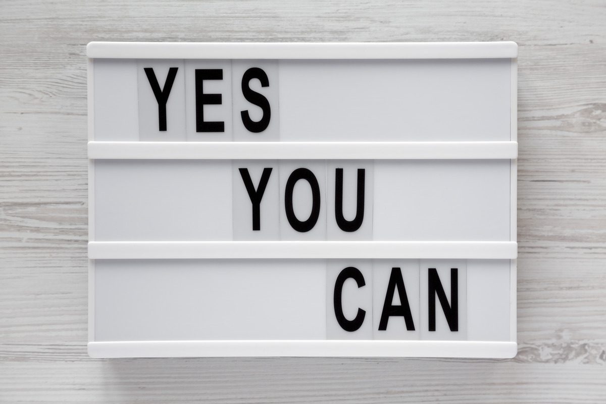 A modern white board with the words "Yes You Can" on display