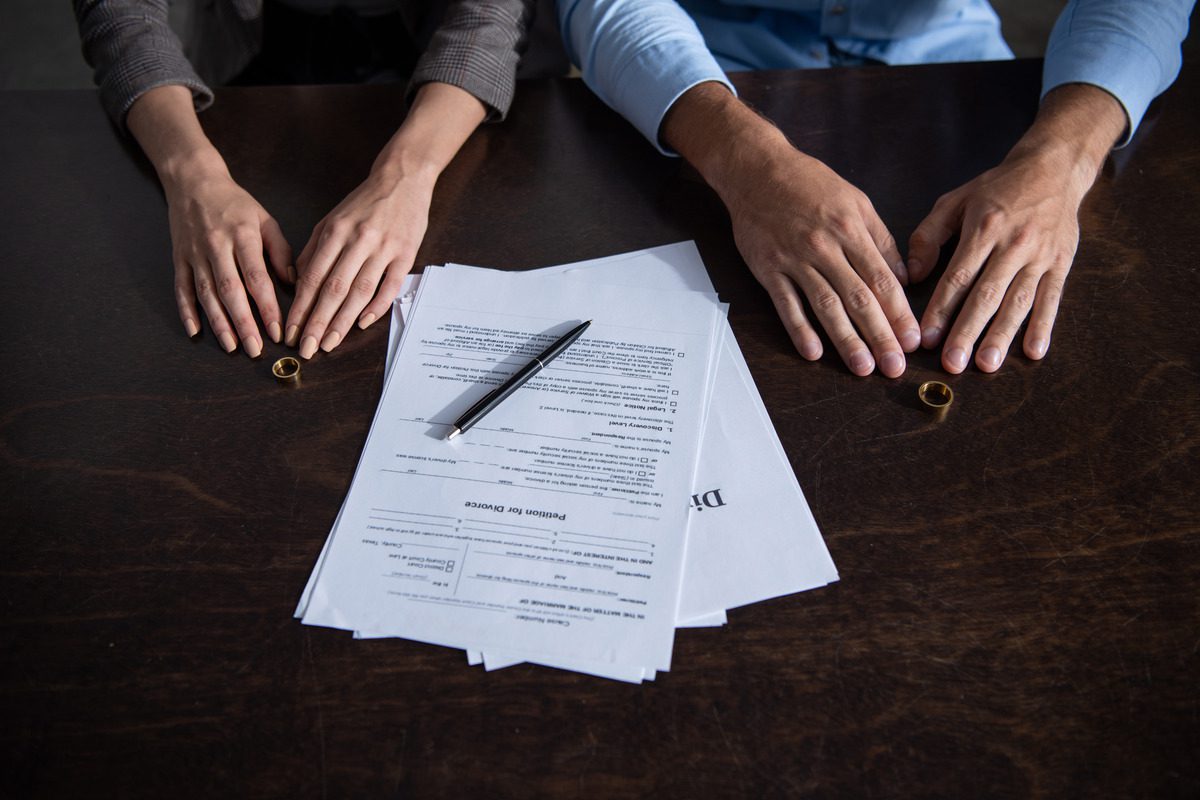 a couple with their rings taken off and the divorce documents on the table