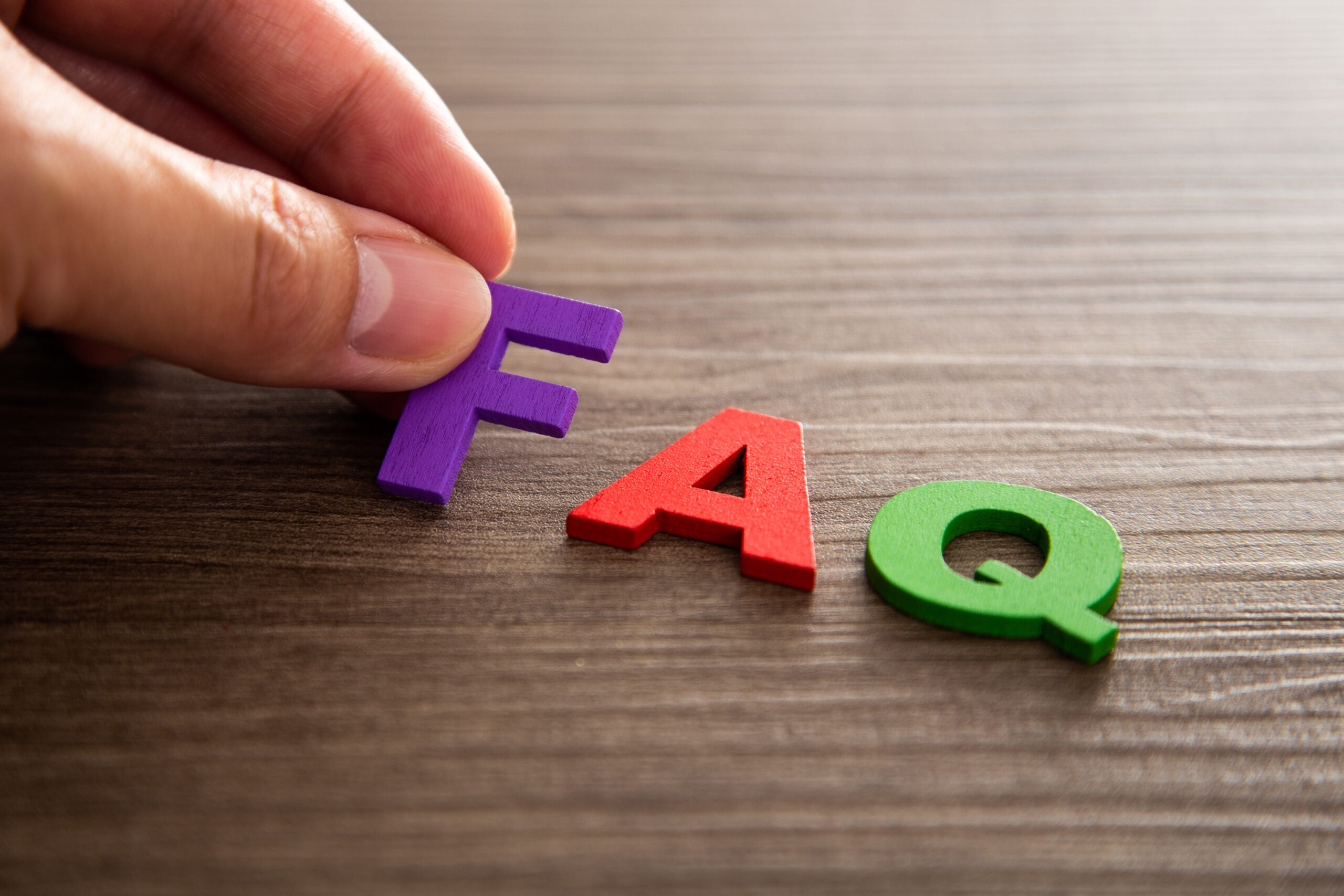 FAQ acronym on wooden blocks, frequently asked questions about divorce, child support, and family law.