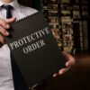 Lawyer or legal professional holding paperwork for a Protective Order (Restraining Order), representing legal assistance for victims