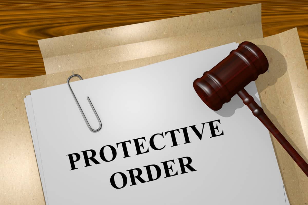 Legal protective order document and judge's gavel, representing domestic violence advocacy, court-ordered restraining orders, and family law protection service