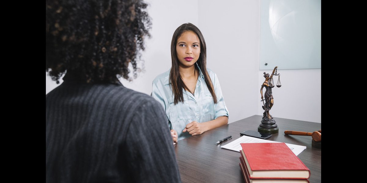 Professional legal consultation between a lawyer and client, featuring a Lady Justice statue and law books, representing family law services, litigation strategy, and expert legal advice