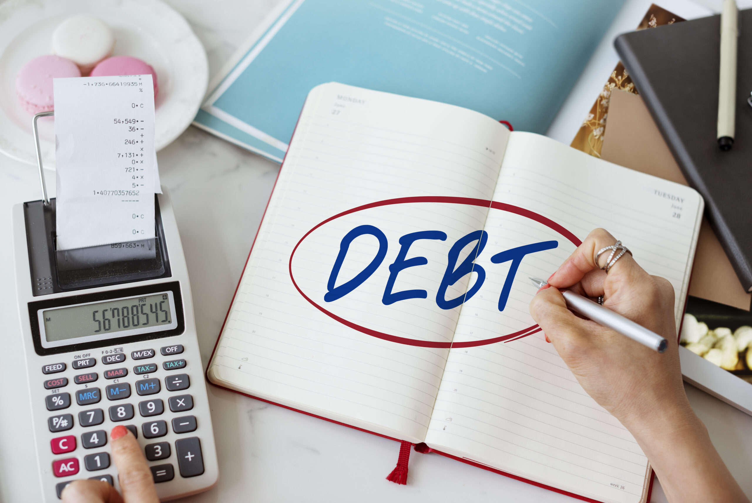 A person calculating expenses and managing debt, representing professional debt relief services, financial planning, credit counseling, and personal insolvency solutions