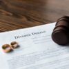 Official divorce decree document with wedding rings and a judge's gavel, representing final marital dissolution, family law court orders, and professional legal services for ending a marriage