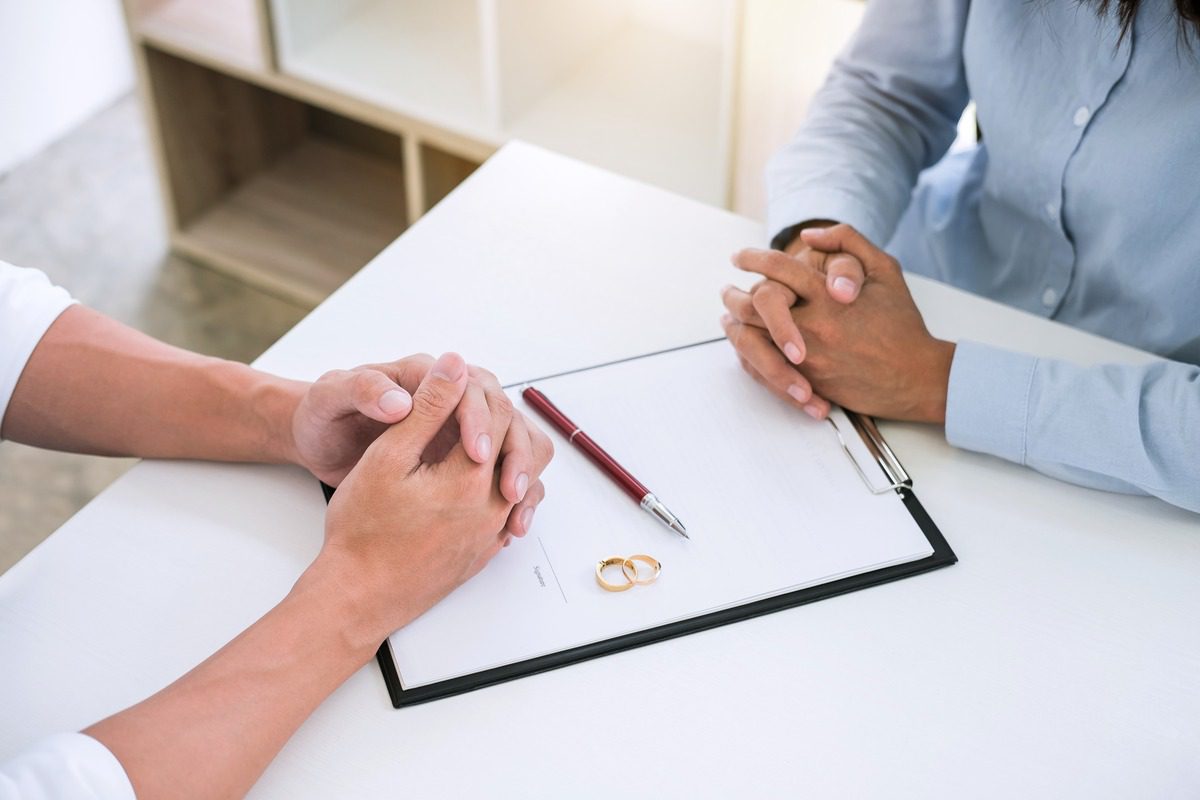 Couples therapy or marriage counseling session symbolized by wedding rings on a desk, illustrating relationship conflict resolution, marital crisis intervention, and professional support