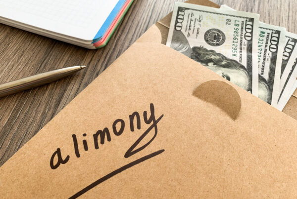 Alimony payment concept with U.S. dollar bills in an envelope labeled “alimony,” representing spousal support, divorce settlements, family law obligations, and post-divorce financial assistance.