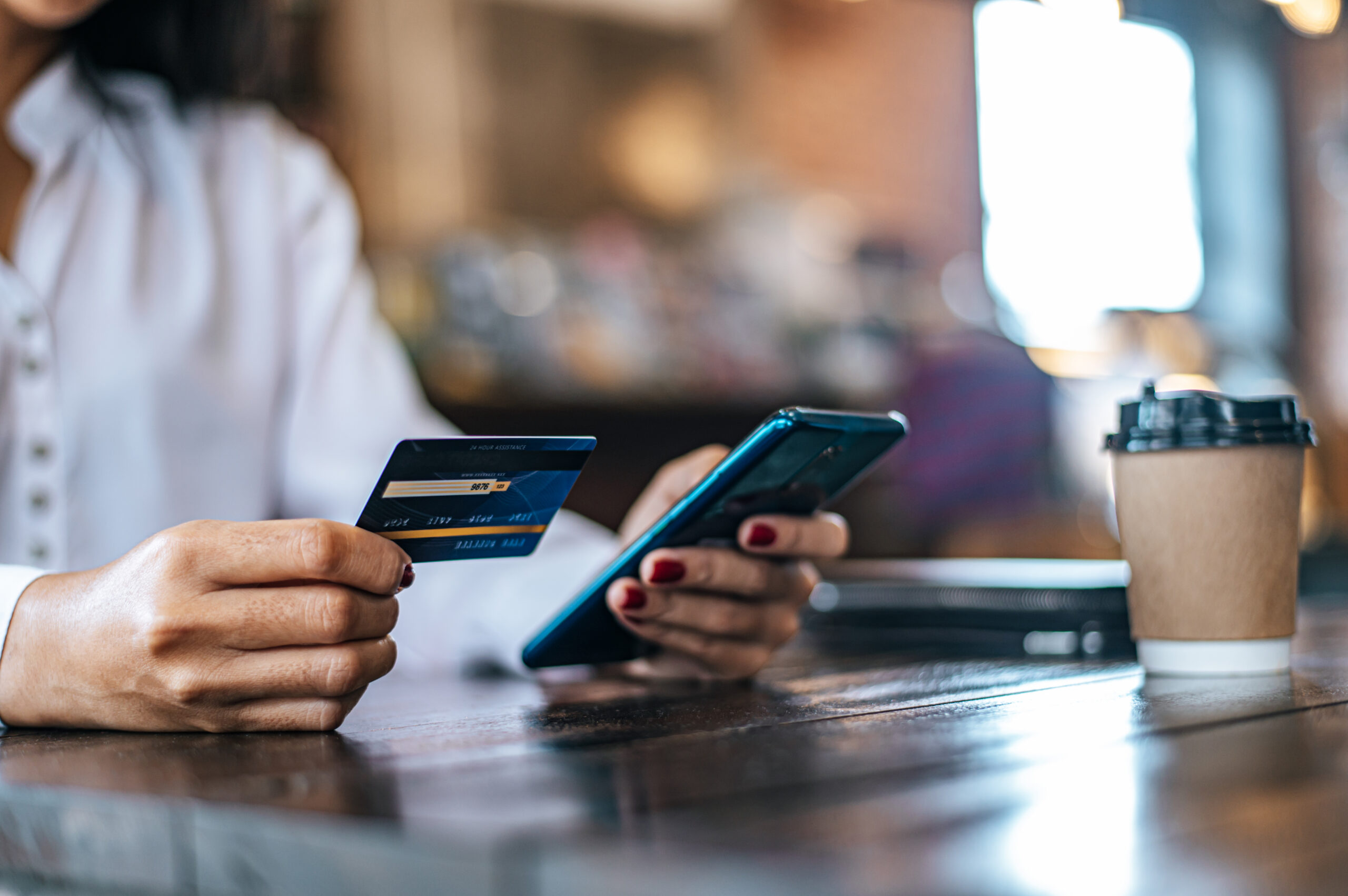 Person using smartphone and credit card for online payment, representing mobile banking, digital transactions, e-commerce shopping, and secure online purchasing