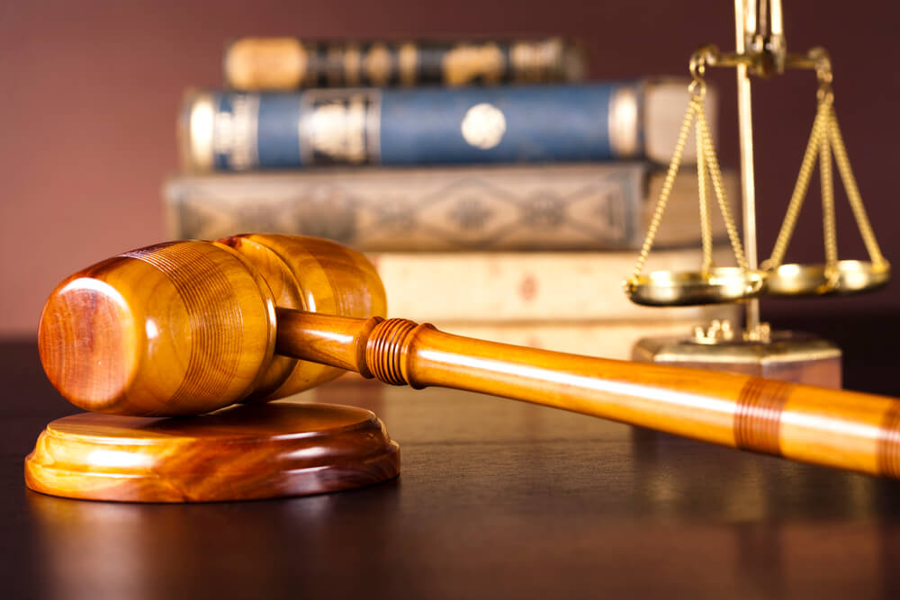 Judge’s gavel on a courtroom desk with scales of justice and law books in the background, symbolizing legal representation, court proceedings, family law services, judicial decisions, and the pursuit of justice.