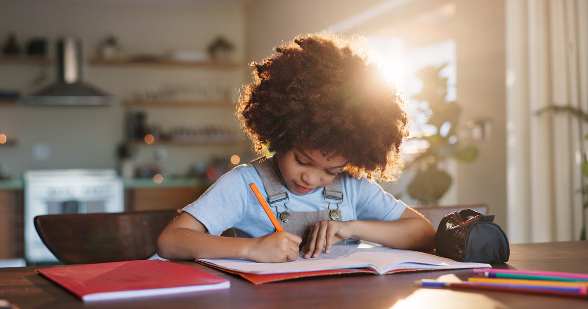 Child studying and writing in a notebook at home, symbolizing child welfare, educational stability, child custody arrangements, family support, and creating a nurturing environment for a child's growth and development