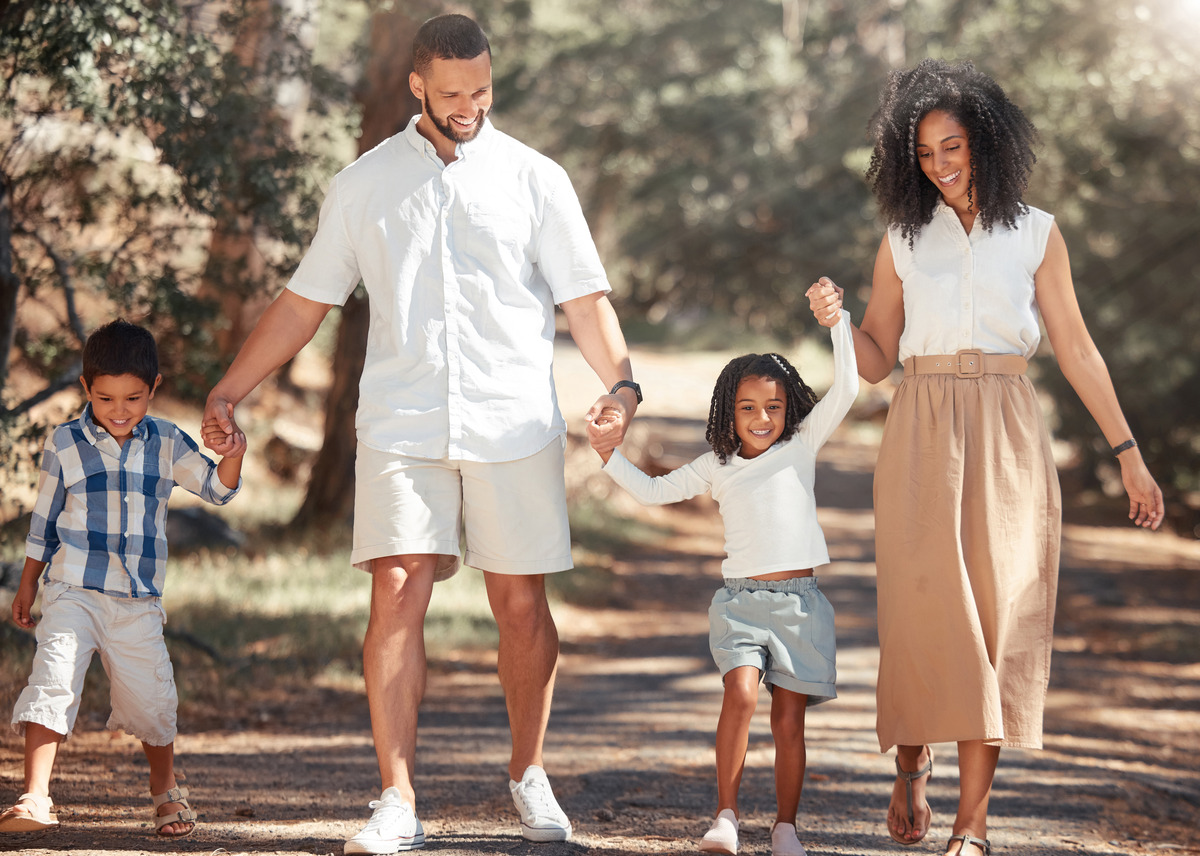 Happy family walking together outdoors while holding hands, symbolizing family adoption, child welfare, parental bonding, permanent family placement, and a loving, supportive home environment for children