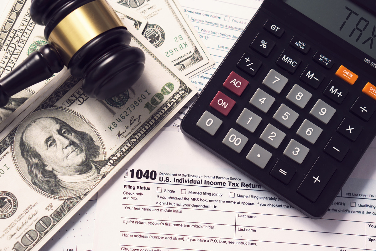 Judge’s gavel, calculator, cash, and tax documents on a desk, symbolizing financial settlements, divorce asset division, child support calculations, alimony payments, and family law financial matters