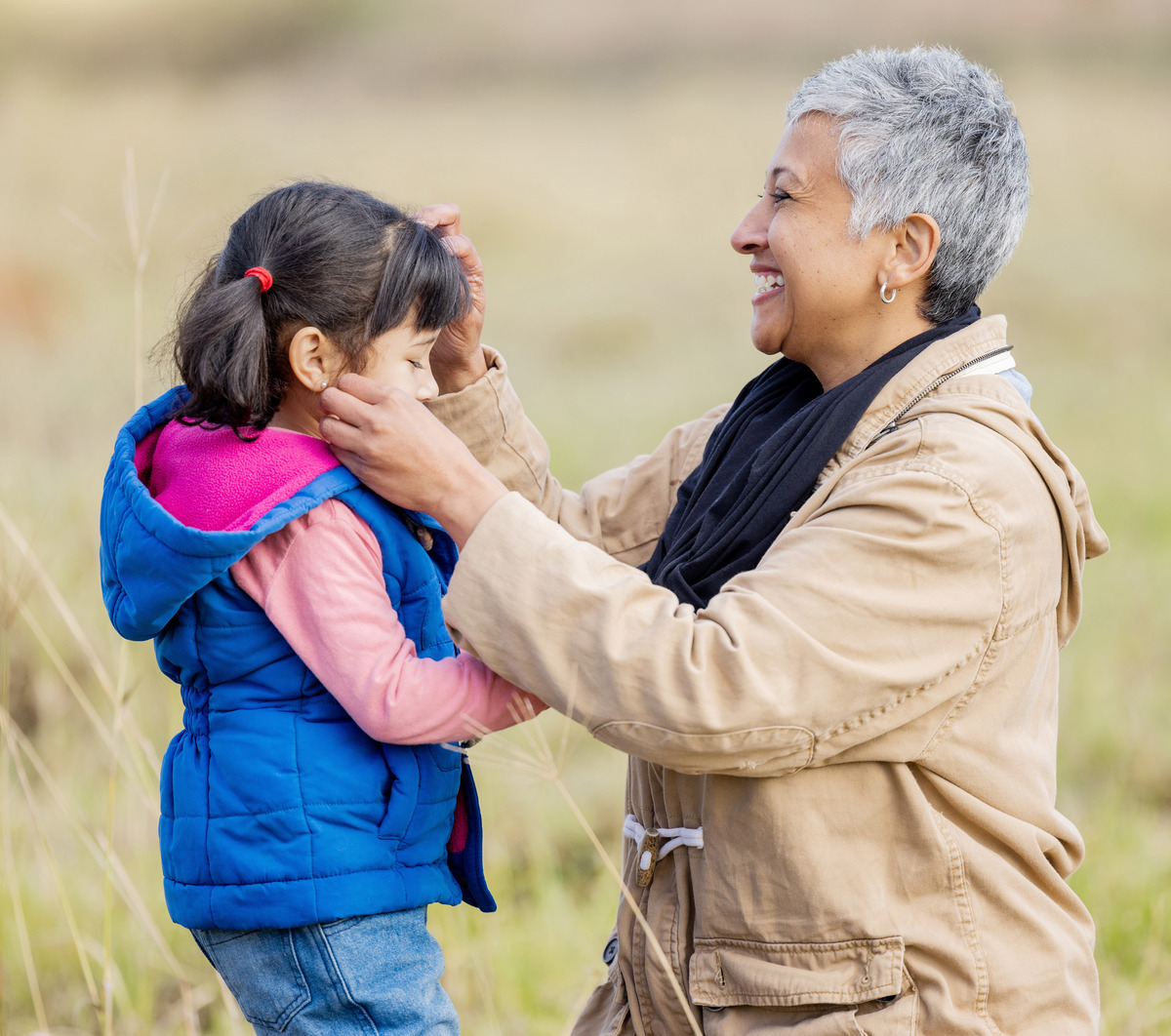 Grandmother gently caring for her granddaughter outdoors, representing grandparents' rights, kinship care, child welfare, family support, emotional well-being, custody arrangements, and the important role grandparents play in providing love, stability, and nurturing care.
