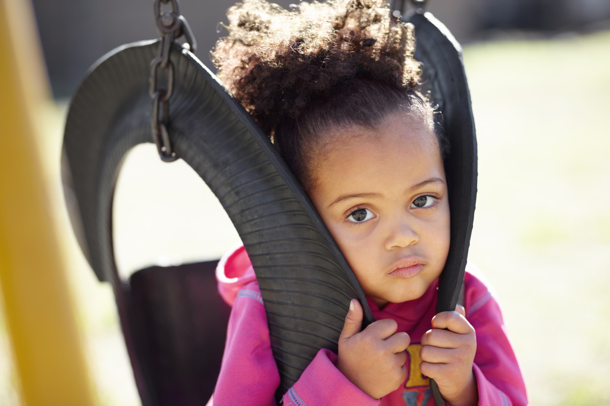 Young child sitting alone on a playground swing, representing child custody concerns, parental rights, child welfare, visitation disputes, and family law matters involving a child’s best interests.